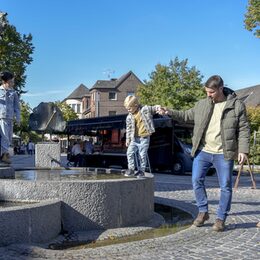Vater mit zwei Söhnen an einem Brunnen in Bergheim
