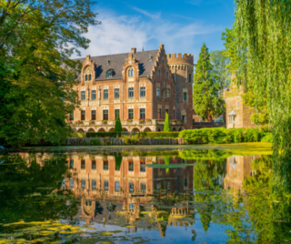 Schloss in Bergheim spiegelt sich im Wasser