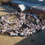 weißgekleidete Schülerinnen und Schüler auf dem Schulhof formieren ein Friedenssymbol